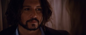 Movie still from “The Tourist” (2010), directed by Florian Henckel von Donnersmarck – A person with long hair and a beard; Close Up shot, Over the shoulder angle
