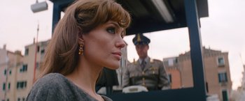 Movie still from “The Tourist” (2010), directed by Florian Henckel von Donnersmarck – A beautiful woman standing in front of a man in a uniform; Close Up shot, Over the shoulder angle