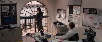 Movie still from “The Tourist” (2010), directed by Florian Henckel von Donnersmarck – Two people are sitting at a desk in an office; Wide shot, Over the shoulder angle
