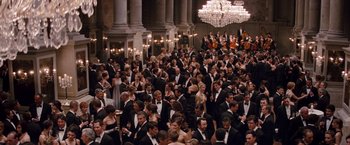 Movie still from “The Tourist” (2010), directed by Florian Henckel von Donnersmarck – A large group of people in formal wear in a room; Extreme Wide shot, High angle