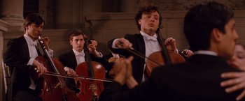 Movie still from “The Tourist” (2010), directed by Florian Henckel von Donnersmarck – A group of men in suits playing musical instruments; Medium shot, Over the shoulder angle