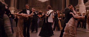 Movie still from “The Tourist” (2010), directed by Florian Henckel von Donnersmarck – A group of people in formal wear dancing in front of a chandelier; Wide shot, High angle