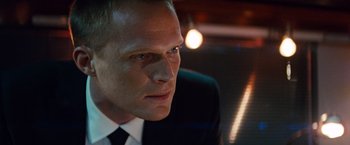 Movie still from “The Tourist” (2010), directed by Florian Henckel von Donnersmarck – A person wearing a suit and tie; Close Up shot, Over the shoulder angle