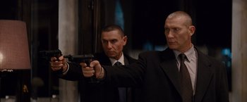 Movie still from “The Tourist” (2010), directed by Florian Henckel von Donnersmarck – Two men dressed in suits and holding a gun; Medium shot, Low angle