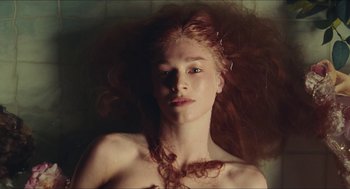 Movie still from “Euphoria” (2019), created by Sam Levinson – A woman with long red hair laying on top of a bed; Close Up shot, Overhead angle