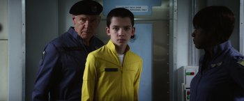 Movie still from “Ender's Game” (2013), directed by Gavin Hood – A man and a young boy standing next to each other in front of an elevator; Medium shot, Over the shoulder angle