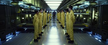 Movie still from “Ender's Game” (2013), directed by Gavin Hood – A group of men in yellow suits standing in a hallway; Wide shot, Low angle