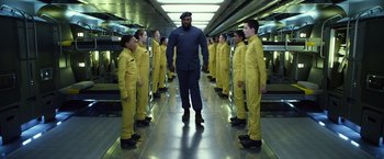 Movie still from “Ender's Game” (2013), directed by Gavin Hood – A group of men in yellow suits standing in a hallway; Wide shot, Low angle