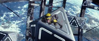 Movie still from “Ender's Game” (2013), directed by Gavin Hood – A man in a yellow and black space suit is in the air; Wide shot, Overhead angle