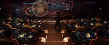 Movie still from “Ender's Game” (2013), directed by Gavin Hood – A man standing in front of a group of people in a room; Wide shot, High angle