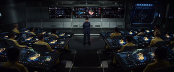 Movie still from “Ender's Game” (2013), directed by Gavin Hood – A man standing in front of a group of people in a room; Wide shot, High angle