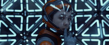 Movie still from “Ender's Game” (2013), directed by Gavin Hood – A man in a helmet and gloves is holding his finger to his lips; Close Up shot, Low angle