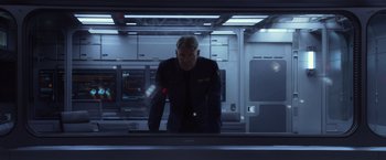 Movie still from “Ender's Game” (2013), directed by Gavin Hood – A man standing in front of a computer monitor; Medium shot, Low angle