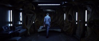Movie still from “Ender's Game” (2013), directed by Gavin Hood – A man in a suit walking in a dark room; Wide shot, High angle