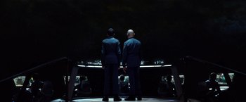 Movie still from “Ender's Game” (2013), directed by Gavin Hood – Two men standing next to each other on a stage; Wide shot, Low angle