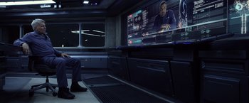 Movie still from “Ender's Game” (2013), directed by Gavin Hood – A man sitting in front of a television screen; Medium shot, Over the shoulder angle