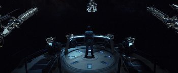 Movie still from “Ender's Game” (2013), directed by Gavin Hood – A man standing on a stage in front of an audience; Wide shot, High angle