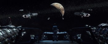 Movie still from “Ender's Game” (2013), directed by Gavin Hood – A man standing in front of an outer space scene; Extreme Wide shot, High angle