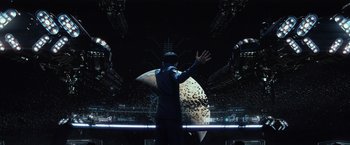 Movie still from “Ender's Game” (2013), directed by Gavin Hood – A man standing in front of an audience in front of a stage; Wide shot, Low angle