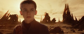 Movie still from “Ender's Game” (2013), directed by Gavin Hood – A young man standing in front of a large rock; Close Up shot, Over the shoulder angle