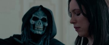 Movie still from “The Town” (2010), directed by Ben Affleck – A person with a skull mask on and a woman looking at them; Close Up shot, Over the shoulder angle