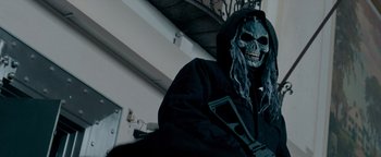 Movie still from “The Town” (2010), directed by Ben Affleck – A person with a skull mask holding a gun; Medium shot, Low angle