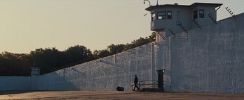 Movie still from “The Town” (2010), directed by Ben Affleck – A man walking down a ramp next to a building; Extreme Wide shot, High angle