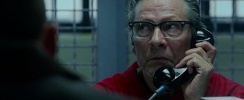 Movie still from “The Town” (2010), directed by Ben Affleck – An older man with glasses is talking on a phone; Close Up shot, Over the shoulder angle
