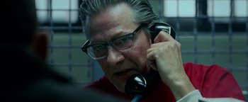 Movie still from “The Town” (2010), directed by Ben Affleck – An older man talking on a phone while wearing glasses; Close Up shot, Over the shoulder angle