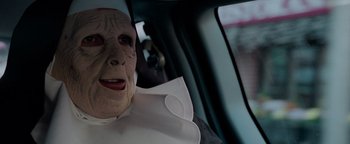 Movie still from “The Town” (2010), directed by Ben Affleck – A person in a car wearing a mask; Close Up shot, High angle