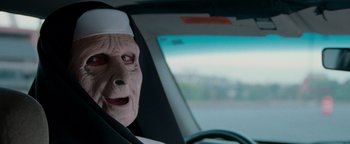 Movie still from “The Town” (2010), directed by Ben Affleck – An old woman in a nun's outfit sitting in the driver's seat of a car; Close Up shot, Over the shoulder angle