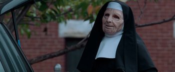 Movie still from “The Town” (2010), directed by Ben Affleck – An old woman in a nun's outfit with tree in the background; Close Up shot, Over the shoulder angle