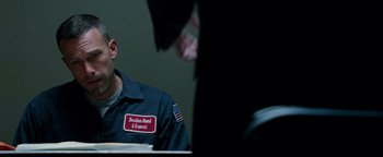 Movie still from “The Town” (2010), directed by Ben Affleck – A man in a blue jacket is sitting at a table; Close Up shot, Over the shoulder angle