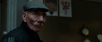 Movie still from “The Town” (2010), directed by Ben Affleck – An old man with a mustache wearing a hat; Close Up shot, Over the shoulder angle