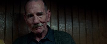 Movie still from “The Town” (2010), directed by Ben Affleck – An older man with a mustache and a beard; Close Up shot, Low angle