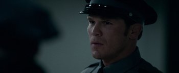 Movie still from “The Town” (2010), directed by Ben Affleck – A man in a police uniform looking to his left; Close Up shot, Over the shoulder angle