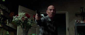 Movie still from “The Town” (2010), directed by Ben Affleck – An older man holding a gun in his hand; Medium shot, Low angle