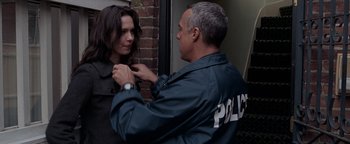 Movie still from “The Town” (2010), directed by Ben Affleck – A police officer fixing a woman's collar; Medium shot, Over the shoulder angle