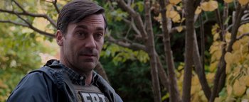 Movie still from “The Town” (2010), directed by Ben Affleck – A person wearing a vest near a tree; Close Up shot, Over the shoulder angle