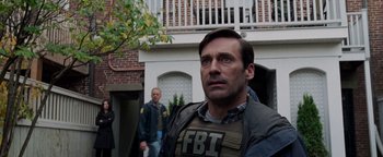 Movie still from “The Town” (2010), directed by Ben Affleck – A man wearing a fbi vest in front of a house; Medium shot, Over the shoulder angle
