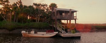 Movie still from “The Town” (2010), directed by Ben Affleck – Two boats are docked at a dock in the water; Extreme Wide shot, High angle