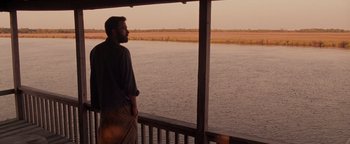 Movie still from “The Town” (2010), directed by Ben Affleck – A man standing on a deck looking out over a body of water; Wide shot, Over the shoulder angle