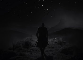 Movie still from “The Tragedy of Macbeth” (2021), directed by Joel Coen – A man is standing in the middle of the night; Extreme Wide shot, Low angle