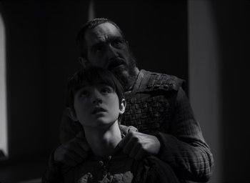Movie still from “The Tragedy of Macbeth” (2021), directed by Joel Coen – A man and a boy are standing next to each other; Close Up shot, Over the shoulder angle