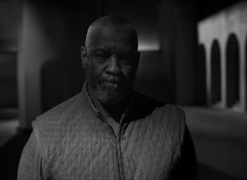 Movie still from “The Tragedy of Macbeth” (2021), directed by Joel Coen – A black and white photo of a man in a jacket; Medium shot, Low angle