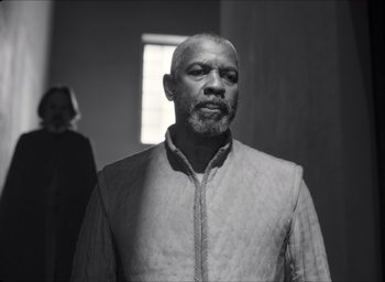 Movie still from “The Tragedy of Macbeth” (2021), directed by Joel Coen – A black and white photo of a man with a beard; Medium shot, Low angle