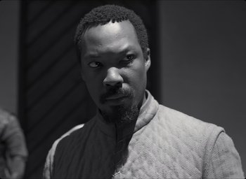 Movie still from “The Tragedy of Macbeth” (2021), directed by Joel Coen – A black and white photo of a man with a strange look on his face; Close Up shot, Over the shoulder angle