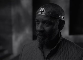 Movie still from “The Tragedy of Macbeth” (2021), directed by Joel Coen – A black and white photo of a man wearing a crown; Close Up shot, Over the shoulder angle