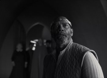 Movie still from “The Tragedy of Macbeth” (2021), directed by Joel Coen – Black and white photograph of a man in a medieval outfit; Medium shot, Low angle