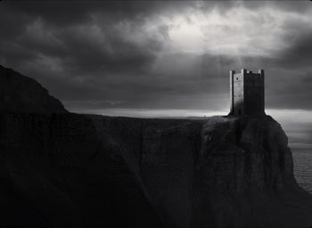 Movie still from “The Tragedy of Macbeth” (2021), directed by Joel Coen – A castle on top of a cliff in the middle of the night; Extreme Wide shot, Low angle